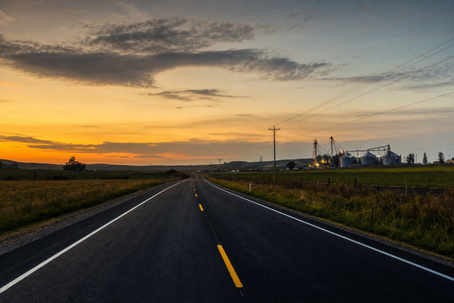 Newly paved roadway stretching into the distance at dusk